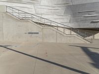 a guy with a skateboard on a sidewalk in front of some stairs and steps