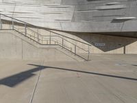 a guy with a skateboard on a sidewalk in front of some stairs and steps