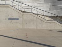 a guy with a skateboard on a sidewalk in front of some stairs and steps