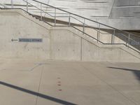 a guy with a skateboard on a sidewalk in front of some stairs and steps