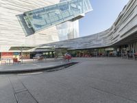 a person is walking around near a water hole at a restaurant area under a glass roof