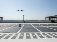 a parking lot with a clock and street lights on top of it next to the ocean