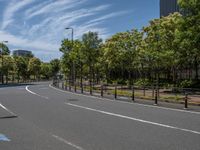 empty road with white lines on the streets of city area against cloudy blue sky on a sunny day