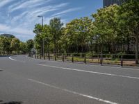 empty road with white lines on the streets of city area against cloudy blue sky on a sunny day