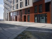 the man is walking in a doorway between two buildings that are made up of wood panels