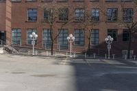 several parking meters and four steps in front of a building in an empty lot with some trees