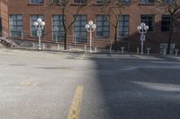 several parking meters and four steps in front of a building in an empty lot with some trees