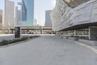 a sidewalk with no traffic on it leads to a large building with buildings behind it