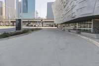 a sidewalk with no traffic on it leads to a large building with buildings behind it