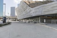 a sidewalk with no traffic on it leads to a large building with buildings behind it