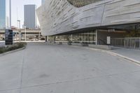 a sidewalk with no traffic on it leads to a large building with buildings behind it