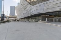 a sidewalk with no traffic on it leads to a large building with buildings behind it