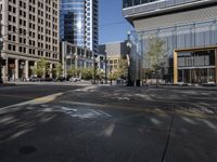 an empty city street and its yellow painted markings on the pavement, with people walking in the middle