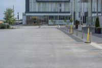 an empty parking lot with a yellow fire hydrant on the side of it, and a tall building in the background