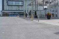 an empty parking lot with a yellow fire hydrant on the side of it, and a tall building in the background