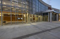 the building has windows that have lots of glass on them and two benches underneath it