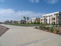 an image of the empty road near the apartments in the background of the blue sky