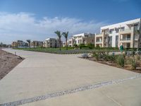 an image of the empty road near the apartments in the background of the blue sky