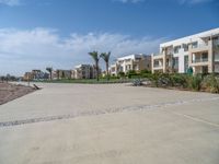 an image of the empty road near the apartments in the background of the blue sky