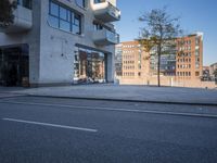 a city street with an empty sidewalk next to a building with glass doors on both sides