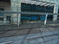 a bench is in front of some very tall buildings, with a blue glass building in the background