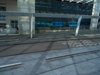 a bench is in front of some very tall buildings, with a blue glass building in the background