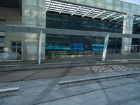 a bench is in front of some very tall buildings, with a blue glass building in the background