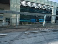 a bench is in front of some very tall buildings, with a blue glass building in the background