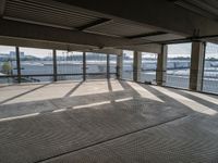 an empty building is shown from inside the terminal doors on the third floor with cars parked in the background