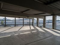 an empty building is shown from inside the terminal doors on the third floor with cars parked in the background