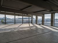 an empty building is shown from inside the terminal doors on the third floor with cars parked in the background