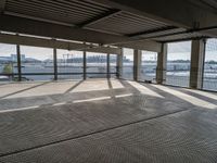 an empty building is shown from inside the terminal doors on the third floor with cars parked in the background