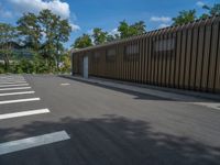 a metal building with a corrugated door in front of it and trees lining the street behind it