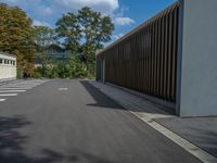 a metal building with a corrugated door in front of it and trees lining the street behind it