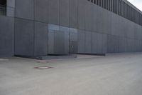 a person wearing a face mask walking across an empty street with a skateboard in the foreground