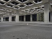 an empty parking garage and a large building in the background at night or day in a large city