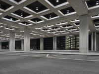 an empty parking garage and a large building in the background at night or day in a large city