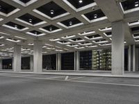 an empty parking garage and a large building in the background at night or day in a large city