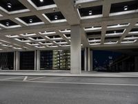 an empty parking garage and a large building in the background at night or day in a large city