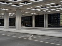 an empty parking garage and a large building in the background at night or day in a large city