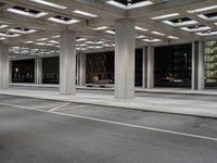 an empty parking garage and a large building in the background at night or day in a large city