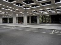 an empty parking garage and a large building in the background at night or day in a large city