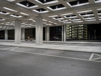 an empty parking garage and a large building in the background at night or day in a large city