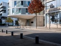 a person standing by a building on the street in front of it and one man walking past them