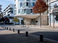 a person standing by a building on the street in front of it and one man walking past them