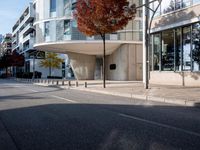 a person standing by a building on the street in front of it and one man walking past them