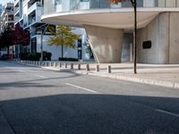 a person standing by a building on the street in front of it and one man walking past them