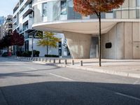 a person standing by a building on the street in front of it and one man walking past them