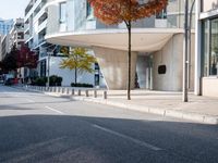 a person standing by a building on the street in front of it and one man walking past them