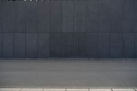 a person wearing a face mask walking across an empty street with a skateboard in the foreground